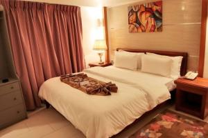 a hotel room with a bed with a dress on it at ADAMAOUA GRAND HOTEL AKWA in Douala