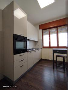 a kitchen with white cabinets and a stove top oven at Appartamento Fiera Vicenza in Vicenza