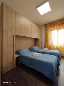 a bedroom with two beds with blue sheets at Appartamento Fiera Vicenza in Vicenza