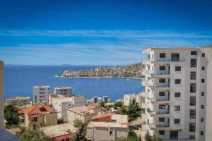 a view of a city and the ocean with buildings at Ari's Apartment Sarande in Sarandë