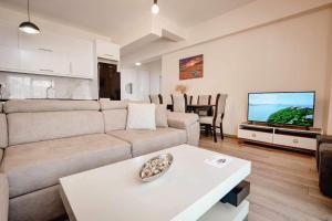 a living room with a couch and a tv at Ari's Apartment Sarande in Sarandë