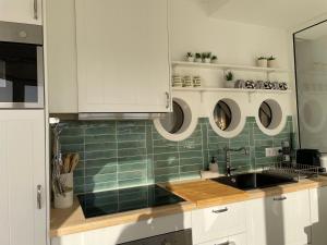 阿爾布費拉的住宿－Ocean Balcony，厨房配有白色橱柜、水槽和绿色瓷砖