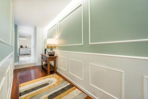 a hallway with white walls and a table with a lamp at Victoria Project - Apartments - Private Parking in Porto