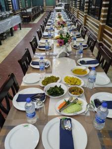 a long table with plates of food and bottles of water at Venus Resort & Coffee House in Bāndarban