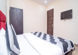 een slaapkamer met een bed en een flatscreen-tv bij Hotel Lembord Inn - BY - New Cashew Hotel in New Delhi