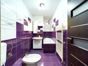 a purple bathroom with a toilet and a sink at Toni’s place in Braşov