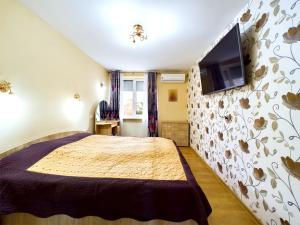 a bedroom with a large bed and a flat screen tv at Toni’s place in Braşov