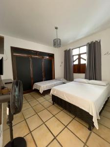 1 Schlafzimmer mit 2 Betten und einem Fenster in der Unterkunft Pousada aconchegante in Jequié