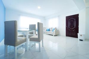 Camera bianca con tavolo, sedie e divano. di Luxurious 1-Bed 1 Bath a Las Flores