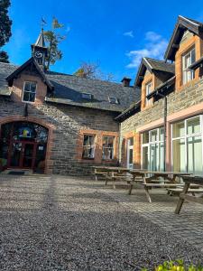 a brick building with benches in front of it at Fairburn Activity Centre in Contin