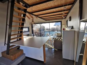 eine Küche und ein Wohnzimmer mit einem Tisch und einer Treppe in der Unterkunft Chalet indépendant au calme à 10 minutes d'Annecy in Villaz