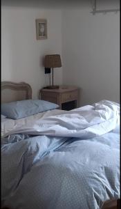 1 cama no hecha en un dormitorio con mesita de noche en Lo noú, en Aosta