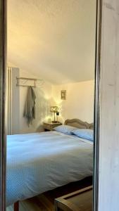 espejo reflejo de una cama en un dormitorio en Lo noú, en Aosta