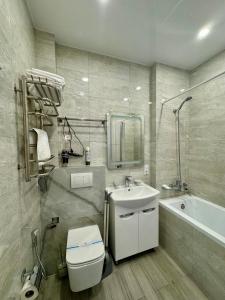 uma casa de banho com um WC, um lavatório e uma banheira em Shtil em Kiev