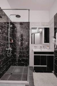 a black and white bathroom with a shower and a sink at Ari's Apartment Sarande in Sarandë +9 photos