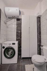 a bathroom with a washing machine and a toilet at Ari's Apartment Sarande in Sarandë