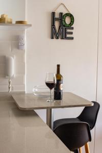 una botella de vino y una copa en una mesa en Hermoso departamento nuevo cerca a servicios, en Lima