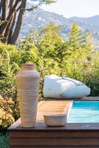 un jarrón sentado en una mesa de madera junto a una piscina en Villa Macera con Palestra e Golf Resté Italy, en Rapallo
