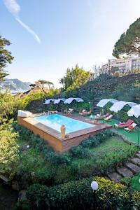 una piscina con sombrillas en una colina en Villa Macera con Palestra e Golf Resté Italy, en Rapallo
