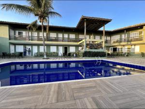 a resort with a swimming pool in front of a building at Vista Mar em Búzios Praia de Geribá c/ Piscina in Búzios