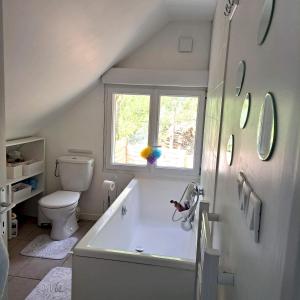 La salle de bains est pourvue d'une baignoire, de toilettes et d'une fenêtre. dans l'établissement Maison de 2 chambres avec jardin clos et wifi a Saint Cyr la Riviere, 