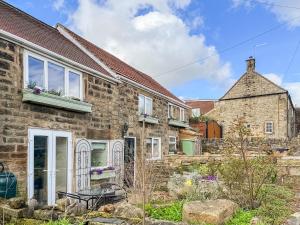 an old brick house with a garden in front of it at Holly Cottage in Ashover