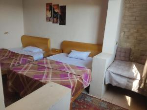 a room with two beds and a chair in it at ElBayt motel in Cairo