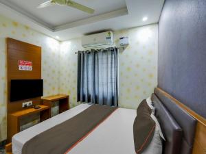 um quarto com uma cama e uma televisão de ecrã plano em Collection O elegant residency em Chennai
