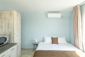 a small bedroom with a bed and a tv at Villa Li Eilat in Eilat