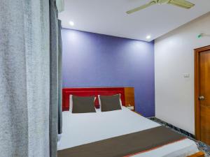um quarto com uma cama e uma parede azul em Collection O elegant residency em Chennai