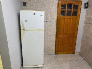 a white refrigerator in a room with a door at Hostel joel 2 in Moreno