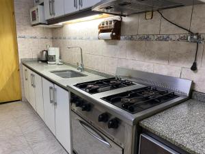 uma cozinha com um fogão e um lavatório em Hostel joel 2 em Moreno