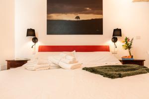 ポリニャーノ・ア・マーレにあるLa casa di Benedettaのベッドルーム1室(白いシーツとタオル付きのベッド1台付)