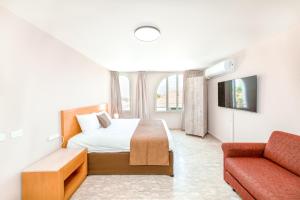 a hotel room with a bed and a couch at Villa Li Eilat in Eilat