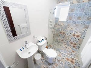uma casa de banho com um lavatório, um WC e um espelho. em Serene 2 & 1 with Amazing Views em Las Flores