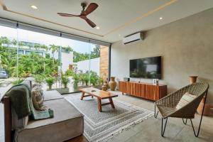 a living room with a couch and a tv at Casa Aventura Secluded Oasis 24h Security Near Sandy Beaches in Tulum