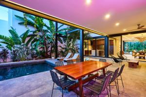 an indoor patio with a table and chairs and a pool at Casa Aventura Secluded Oasis 24h Security Near Sandy Beaches in Tulum