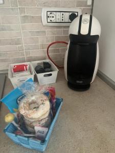 una macchinetta del caffè seduta accanto a una scatola di cibo di Casa Marina a Carloforte