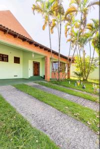 uma casa com palmeiras ao lado de um passadiço em Casa na Granja Viana - Cotia em Cotia
