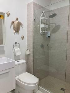 a bathroom with a toilet and a shower with a turtle on the wall at Aruba's Life Vacation Residences - By Heritage Property Management in Noord