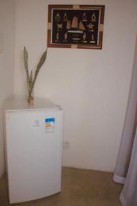a white refrigerator in a room with a picture on the wall at Casa Azul Caraíva - Casas Do San in Caraíva