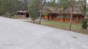 a log cabin with a driveway in front of a house at Käina Jahimaja in Käina