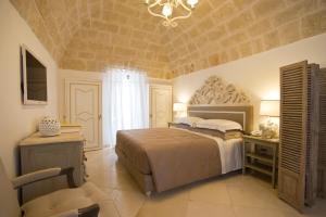 a bedroom with a large bed and a chandelier at Hotel Don Ferrante in Monopoli