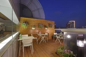 a patio area with a table, chairs, and a balcony at Eastin Taipei Hotel in Taipei