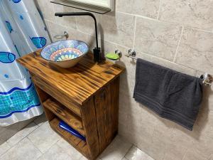 Hostel joel 2 في مورينو: حمام مع وعاء على منصة خشبية مع حوض
