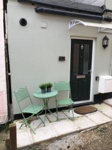 a table and chairs sitting in front of a door at Dinky cottage in Brightlingsea