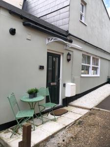 a patio with two chairs and a table in front of a house at Dinky cottage in Brightlingsea