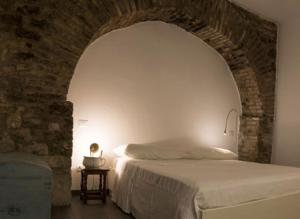sypialnia z łóżkiem i ceglaną ścianą w obiekcie Residenza La Corte Assisi w Asyżu