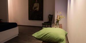 una sala de estar con una almohada verde y una silla en Residenza La Corte Assisi, en Asís