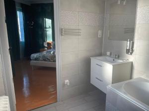 a white bathroom with a sink and a mirror at Le Palace in Orléans